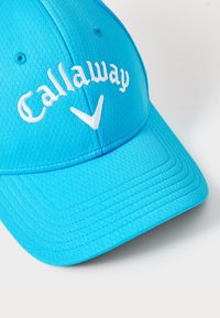 Kék sapka textúrált anyagból, ívelt napellenzővel. Fehér hímzett "Callaway" logóval és egy fehér kiegészít�ő logóval rendelkezik.
