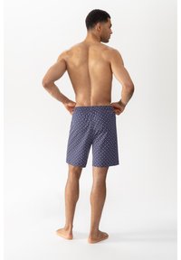 Zwemshorts voor heren met een marineblauwe achtergrond en een geometrisch patroon van rode en witte stippen, gemaakt van lichtgewicht, snel drogend materiaal.