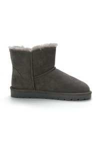Stivaletto in suede grigio con una fodera morbida e vellutata, punta tonda, suola bassa e piatta, e un dettaglio cucito sul lato.