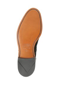Semelle en cuir marron avec une finition lisse, présentant un bord surélevé et un logo en relief. Talon en caoutchouc texturé pour une meilleure adhérence et durabilité.