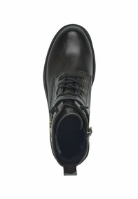 Bottine en cuir marron avec un bout rond, un laçage, une doublure douillette et une fermeture éclair sur le côté pour un accès facile. Présente des œillets en laiton.