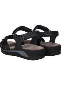 Zwarte sandalen met brede banden, gevlochten details, een geveerd voetbed en een dikke zool met een grijze accent. De achterkant toont verstelbare gespen.