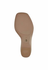 Beige shoe sole with smooth surface, rounded shape, and subtle texture. Features a logo and size details embossed on the heel section.