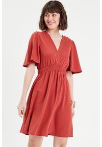 Vestido de color óxido con escote en V, mangas cortas con volante, cintura fruncida y falda acampanada, hecho de un tejido suave y texturizado.