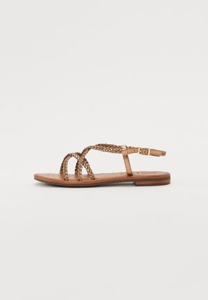 Sandalias planas con tiras trenzadas metálicas y cierre de hebilla lateral, con una plantilla color marrón y un tacón bajo en capas.