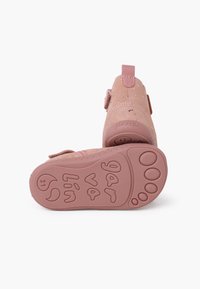 Zapatos de ante rosa para niños con una correa de Velcro, punta redondeada y suela de goma rosa texturizada con detalles en relieve.