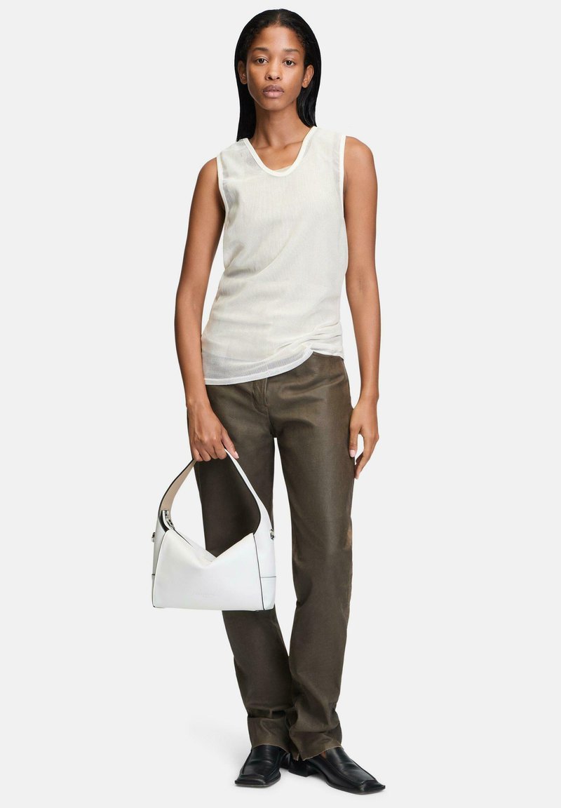 Biała bezrękawnikowa bluzka z teksturowanej tkaniny, oliwkowe spodnie o prostym kroju oraz biała skórzana torebka z czarnymi akcentami. Czarne buty.