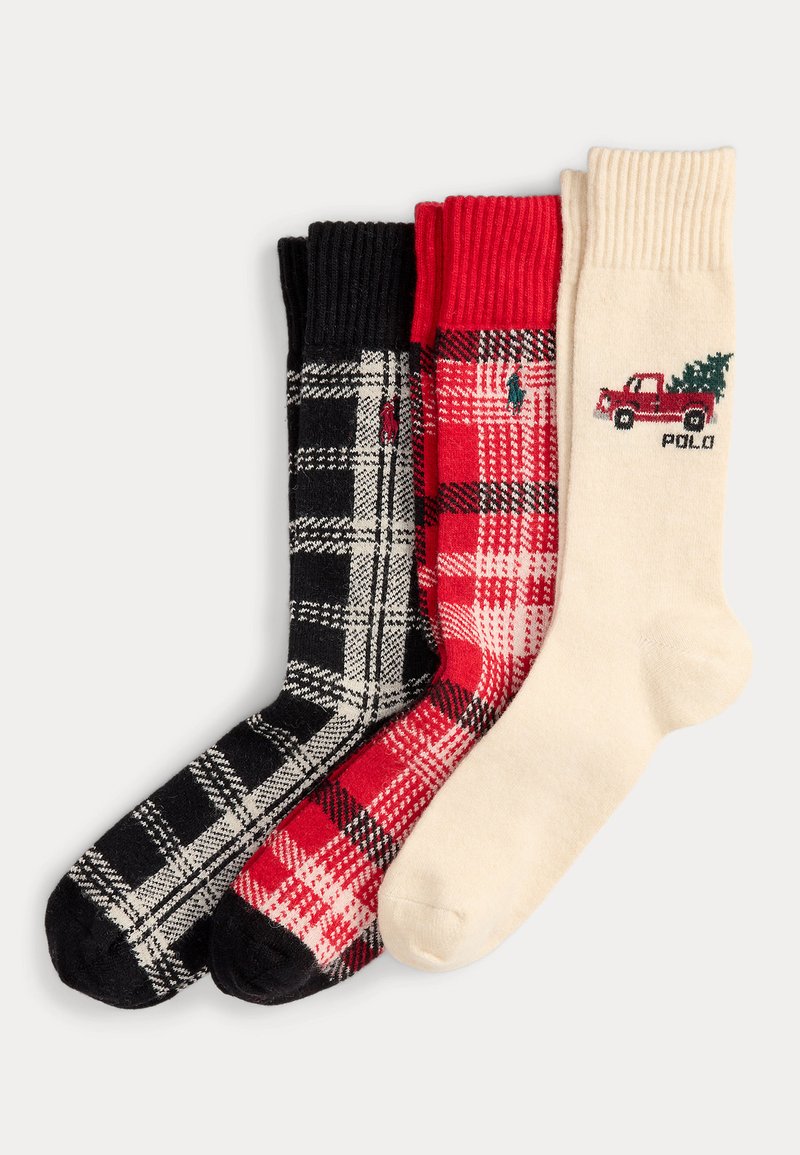 Tres pares de calcetines: uno de cuadros en blanco y negro, otro de cuadros rojos, y uno crema con un gráfico de un camión rojo. Todos cuentan con puños acanalados y una textura suave.
