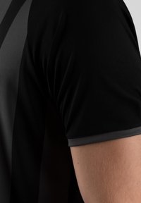 Maglietta sportiva nera con maniche corte, texture liscia, dettagli grigi e un design con strisce verticali a contrasto.