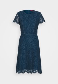 Spetsklänning i mörk marinblå med korta ärmar, en figurnära överdel och en vågig nederkant. Har blommiga spetsmönster och rund halsringning.