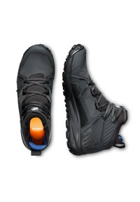 Svarta vandringsskor med en texturerad ovandel, förstärkt tåhätta och en kontrasterande orange innersula. Har en tjock gummisula och ett integrerat snörningssystem.