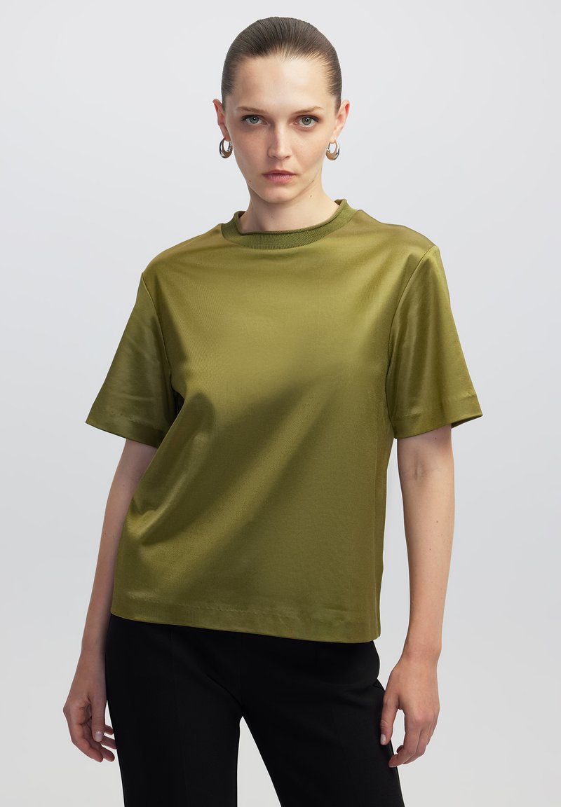 Olijfgroene top met korte mouwen en een ronde halslijn, gemaakt van gladde, glanzende stof. Heeft een ontspannen pasvorm en een minimalistisch ontwerp.