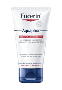 Weißer Behälter mit blauem Boden, beschriftet mit "Eucerin Aquaphor Protect & Repair." Enthält Informationen auf Deutsch zur Hautbehandlung bei trockener Haut.