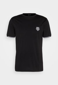 Camiseta negra de tejido suave con un gráfico de un león en el lado izquierdo del pecho, con un borde blanco en contraste en las mangas.
