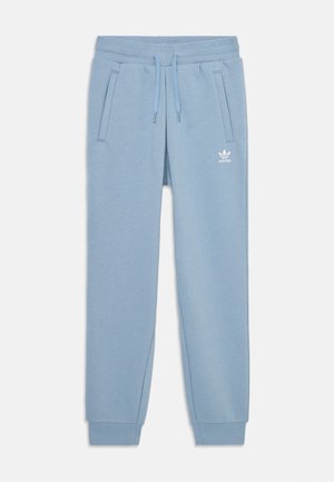 Vaatekulho vaaleansiniset collegehousut, joissa on pehmeä kangas, nyörikiinnitysvyötärö, kaksi sivutaskua ja valkoinen Adidas-logo vasemmassa reidessä.