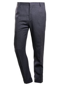 Pantalones de vestir para hombre en gris oscuro, a medida, con trabillas para cinturón, pliegue frontal y dobladillos con vuelta, sobre un fondo blanco.