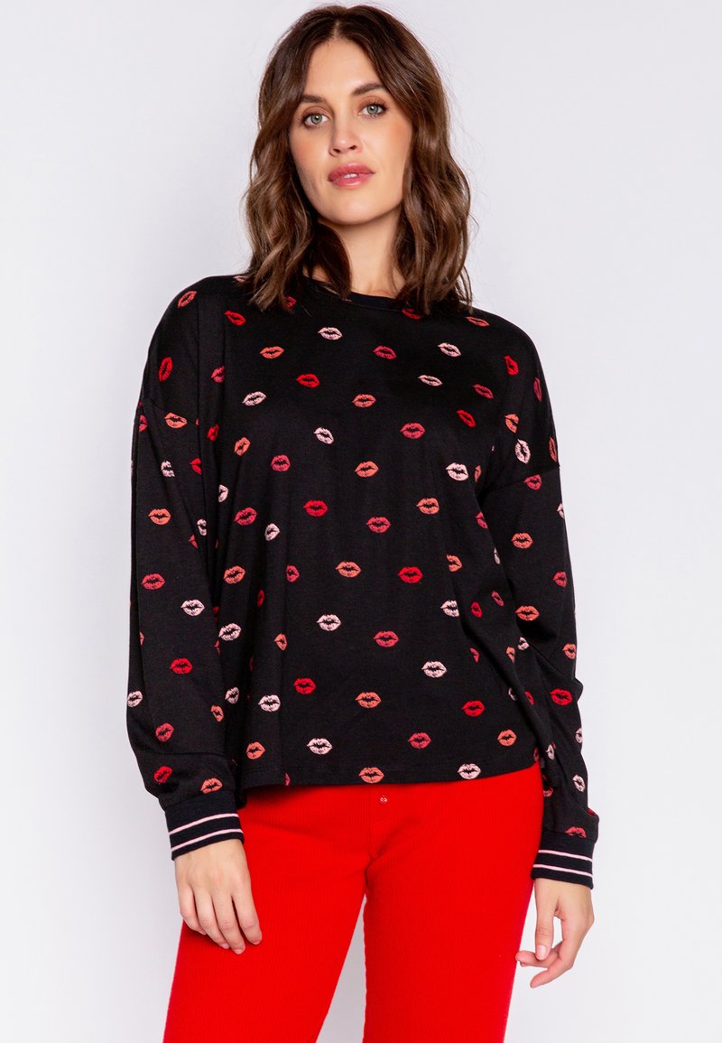 Svart sweatshirt med ett mönster av färgglada läpptryck i rött och rosa. Designen inkluderar ribbade ärmslut och en avslappnad passform.