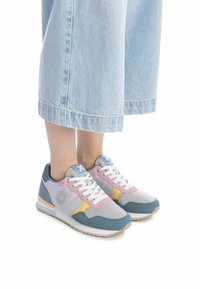 Deportivas multicolores que presentan una mezcla de materiales en gris, rosa, amarillo y azul. Parte superior de malla, suela de goma y cordones blancos. Diseño de punta redondeada.