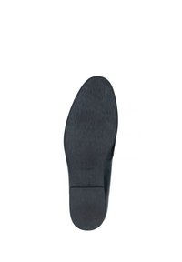 Suela de zapato de cuero negro con una textura suave, forma redondeada y un sutil logotipo cerca del talón. Diseño minimalista sin patrones distintivos.
