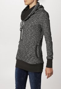 Szary melanżowy sweter z kapturem, kontrastującym ciemnym kołnierzem, kieszeniami z przodu oraz detalem w postaci sznurka. Długie rękawy i dopasowany krój.