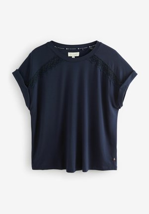 Camiseta de manga corta en azul marino, fabricada con una tela suave, que presenta paneles de encaje en los hombros, corte holgado y escote redondeado.