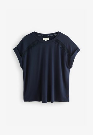 T-shirt à manches courtes bleu marine en tissu lisse, avec des accents en dentelle sur les épaules, coupe décontractée et encolure ronde.
