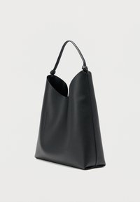 Čierna kožená taška na rameno s konštrukčným dizajnom, ktorá má široký otvor, tenký rukoväť a štruktúrovaný povrch.