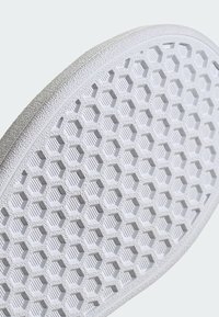 Suela de zapato blanca con un patrón hexagonal texturizado y un borde elevado. El material parece de goma con un acabado suave.