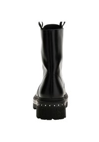 Bottine en cuir noir avec une finition lisse, bout rond, languettes de tirage et accents cloutés sur la semelle épaisse ornée du nom de la marque en relief.