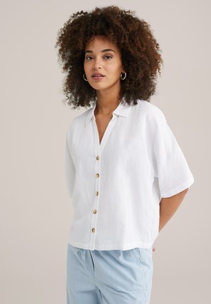 White linen button-up shirt with short sleeves and a collar, featuring golden buttons down the front and a relaxed fit.