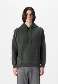 Hanorac din fleece verde închis, cu buzunar tip kangaroo, șnururi ajustabile și manșete cu nervuri; are brodate texte pe piept.