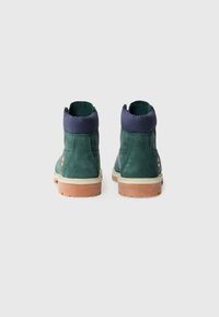 Stivaletti alla caviglia verde in suede con colletto in tessuto blu e suola in gomma beige chiaro. Presentano un piccolo dettaglio con logo sul tallone.