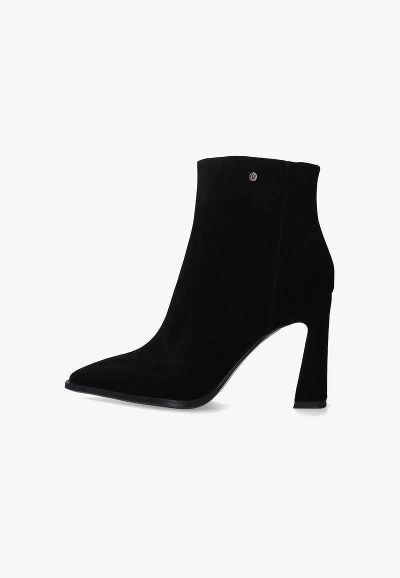 Czarne zamszowe botki sięgające kostki z ostrym noskiem i eleganckim wysokim obcasem. Zawierają mały metaliczny akcent z logo po zewnętrznej stronie.