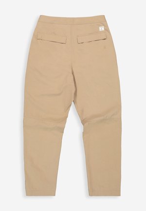 Beige broek plat gelegd met zicht op de achterkant, voorzien van twee klepzakken en een klein wit label aan de rechterkant van de tailleband.