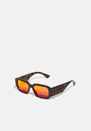 Óculos de sol em padrão tartaruga com armações angulares, apresentando lentes laranja degradê e uma marcação discreta nas hastes. Acabamento texturizado.