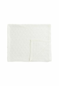 White knitted blanket featuring a textured polka dot pattern, with a ribbed edge along one side. Soft fabric material provides warmth.