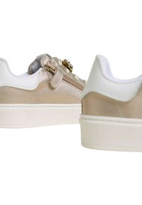 Sneaker eleganti in beige metallico e bianco, dotate di una cerniera laterale, tomaia testurizzata e suola in gomma liscia. Design minimalista e dettagli raffinati.