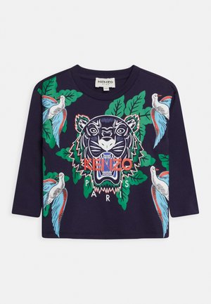 Marineblaues Langarmhemd mit zentralem Tigerkopf-Grafik, grünen Blättern, blauen und weißen Vögeln und rotem "KENZO PARIS" Text vorne.