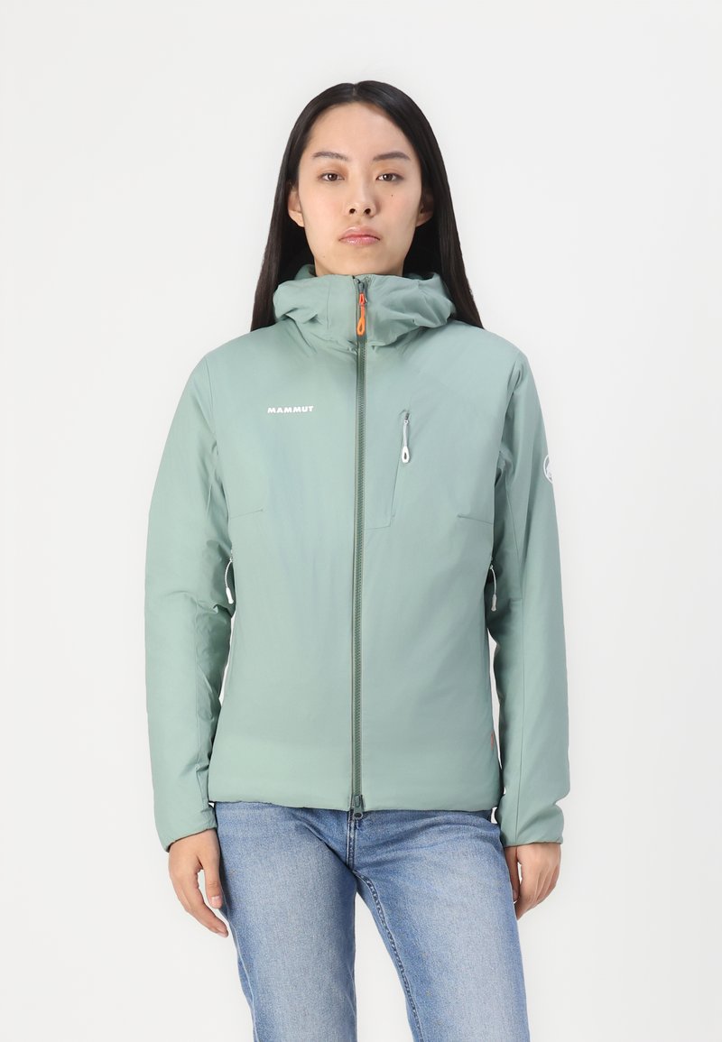 Jasnozielona kurtka ocieplana z dopasowaną kapturem, zapinana na zamek z przodu oraz kieszenią na piersi; posiada elastyczne mankiety i kontrastowe pomarańczowe akcenty.