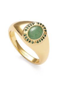 Anillo de oro con una gran piedra verde, rodeada de pequeñas piedras verdes en un ajuste circular. Banda lisa y pulida con forma cónica.