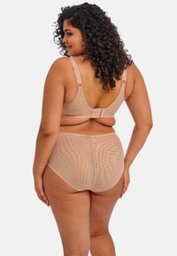 Alusharja paljaste rihmadega ja klapiga sulgemise tagaosa, vürtsitatud vastava kõrge taljega aluspükstega. Mõlemad omavad tekstuuriga, siledat viimistlust.