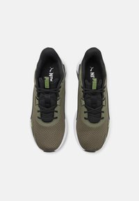 Baskets de sport en mesh vert avec accents noirs et lacets. Présentent un col rembourré et une semelle intermédiaire blanche. Logo sur la languette et le côté.