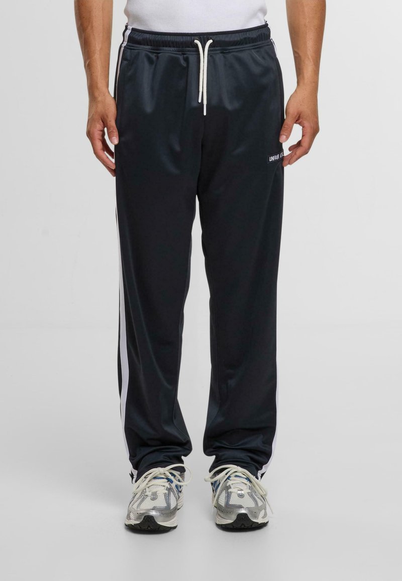 Sötétkék sport futópants, fehér oldalsávokkal, elasztikus derékkal, húzózsinórral és logó részlettel a bal combon; sima szintetikus anyag.