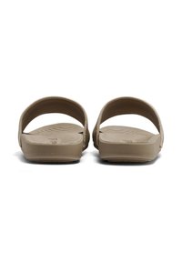 Light brown slide sandals with a textured footbed and smooth upper straps. Flat sole with a minimal design and no visible hardware.