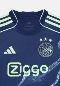 Mørkeblå fotballdrakt med lys grønne detaljer, som har Adidas-logoen, Ziggo-merkevaren og et rundt emblem med design av en historisk figur.
