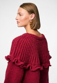 Suéter de punto burdeos con textura acanalada y acentos ondulados en el cuello y las mangas. Material suave y grueso.