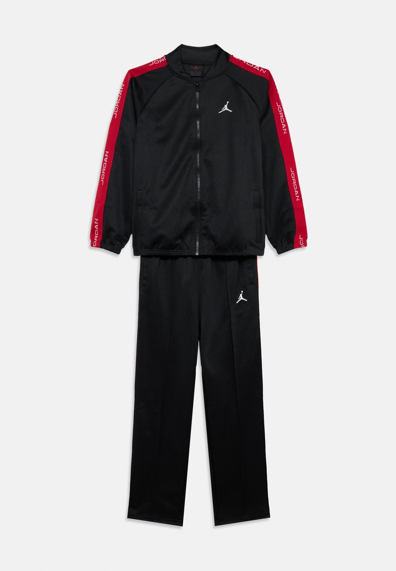 Chándal negro con rayas rojas en las mangas y los pantalones, con logotipos Jumpman blancos y texto "Jordan" en las rayas rojas.