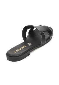 Chancla negra hecha de material sintético, con tiras cruzadas, plantilla ligeramente texturizada y costuras blancas contrastantes a lo largo de los bordes.