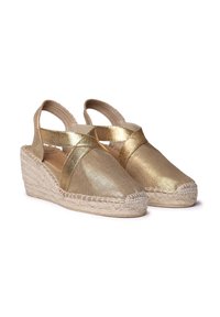 Espadrillas con zeppa in tessuto dorato, design a strappo incrociato e suole in juta. Texture liscia con finitura lucida. Tacco chiuso e punta aperta.
