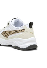 Vit och beige sneaker med leopardmönstrad detalj, texturerade material, vadderad sula och svart dragflik vid hälen.